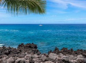 A view of the Ocean with a Sailboat in the Distance