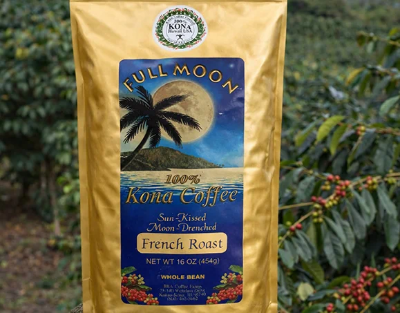 Bag of Full Moon 100% Kona Coffee French Roast whole bean in a coffee farm field on the Big Island