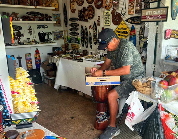 Local vendor selling Hawaiian crafts, souvenirs, and leis at the Kona farmers market
