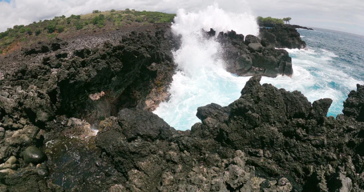 Waves crashing through a lava rock blowhole on the Kona coastline, Big Island Hawaii